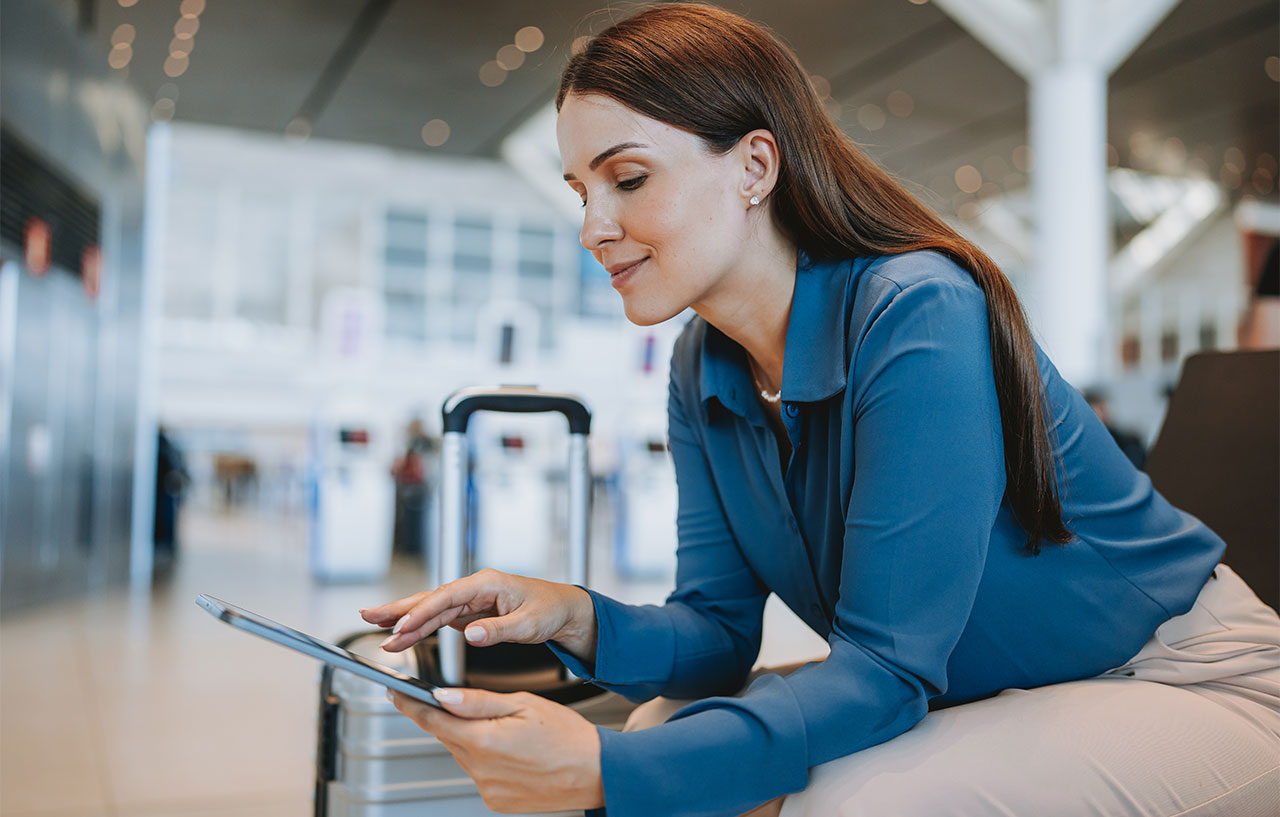 business woman at the airport sitting looking at tablet